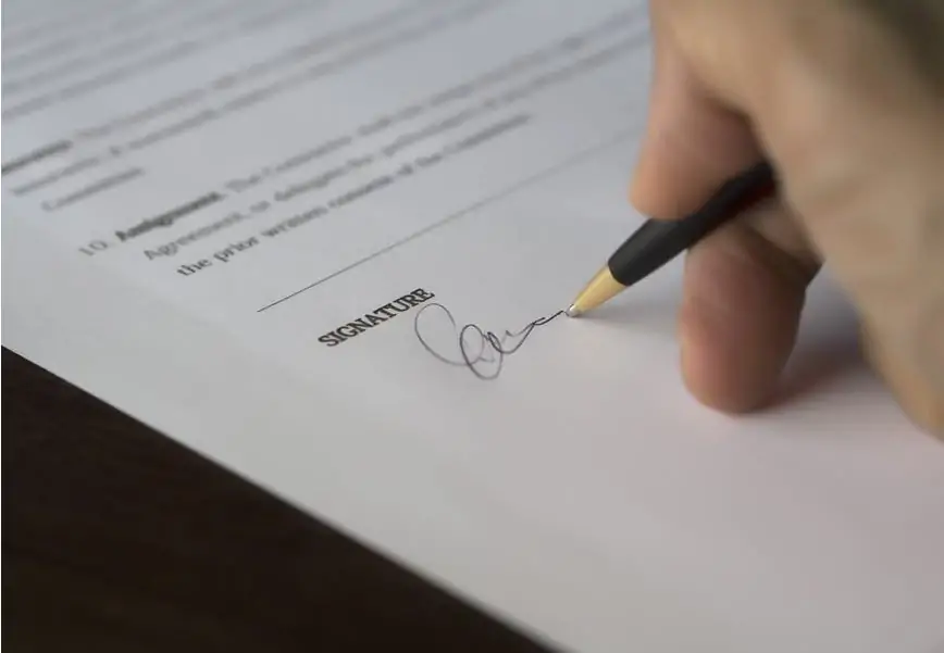 A person signing a warranty plan.