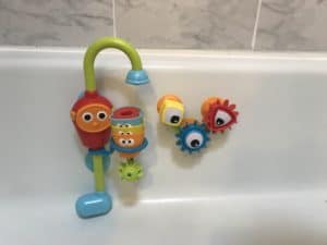 Colorful bath toy that has gears and spout for water.
