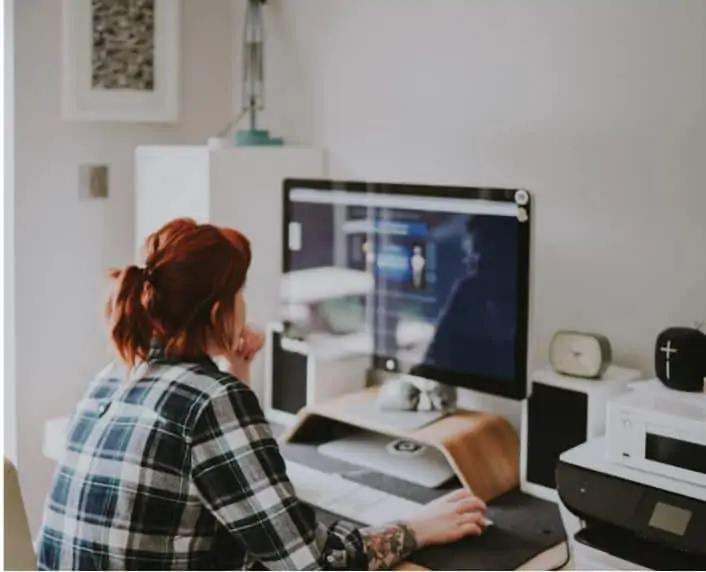 A woman sitting at her desk working as a travel agent from home.