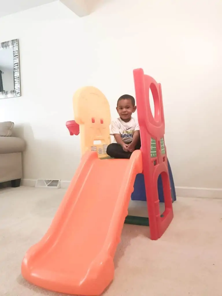 Indoor slide a with basketball hoop.