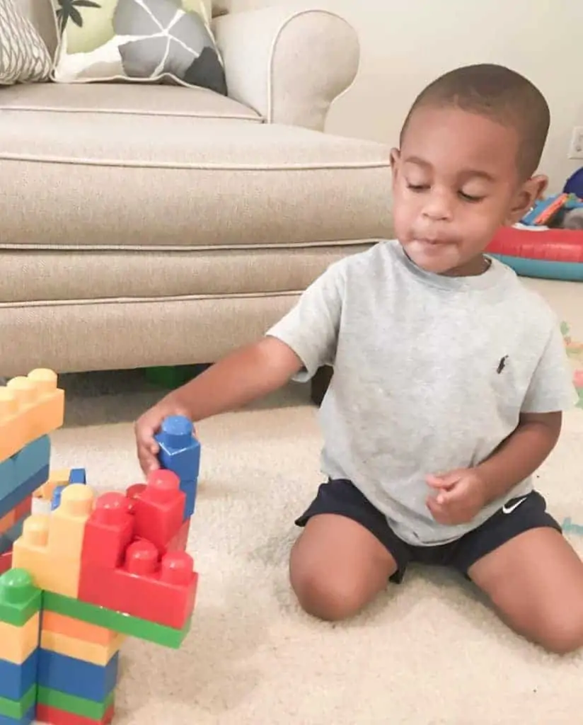 A young boy playing with duplo blocks.