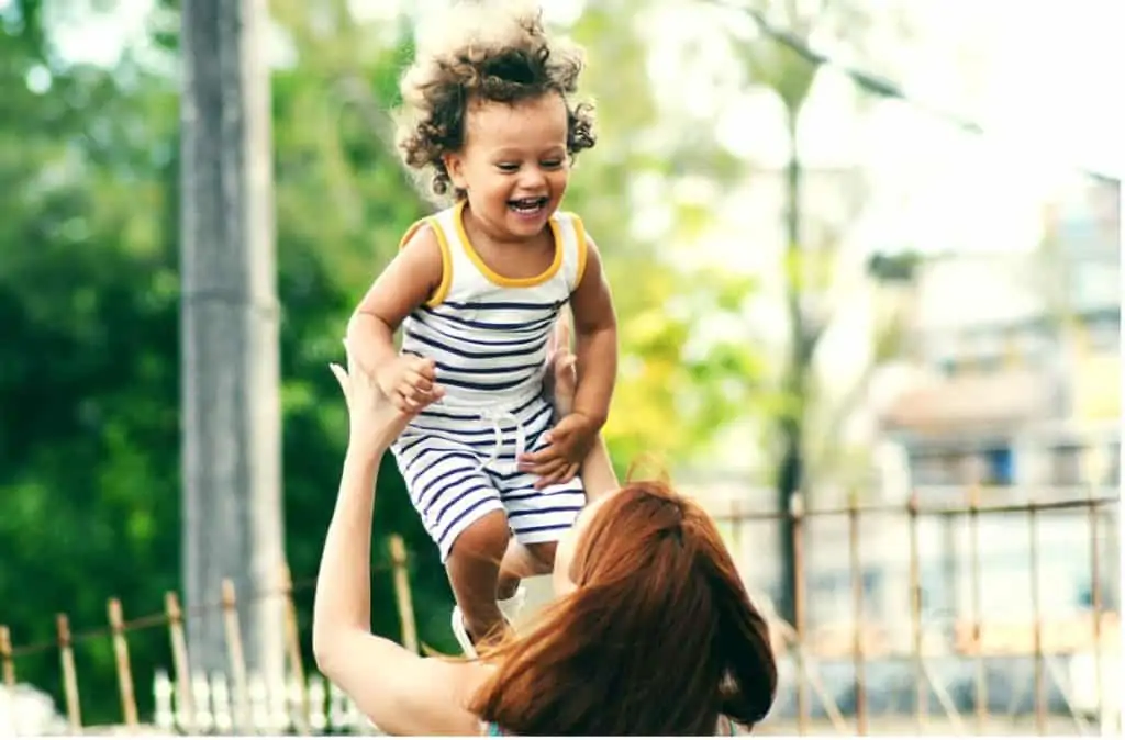 A mother playfully throwing her child into the air