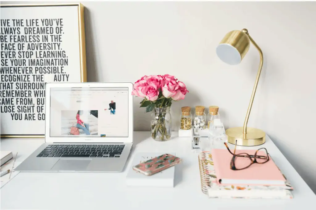 A woman's workplace with a laptop and flowers where she creates her blog