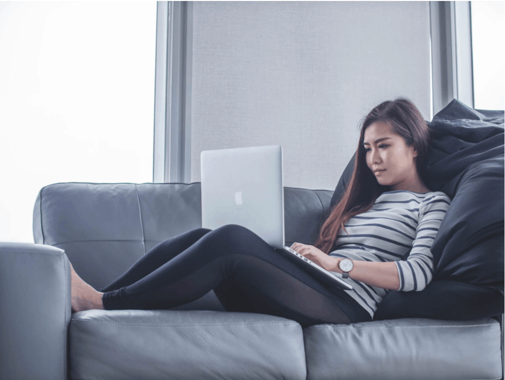 Mom on her couch with her laptop looking for a online job from home without investment. 