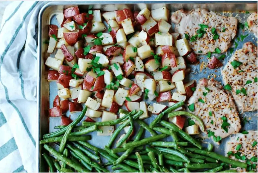 Fish, green beans and potatoes on a cookie sheet