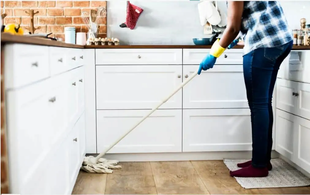 A woman mopping her kitchen floor.