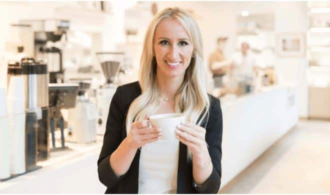 A woman in a coffee shop enjoying a coffee