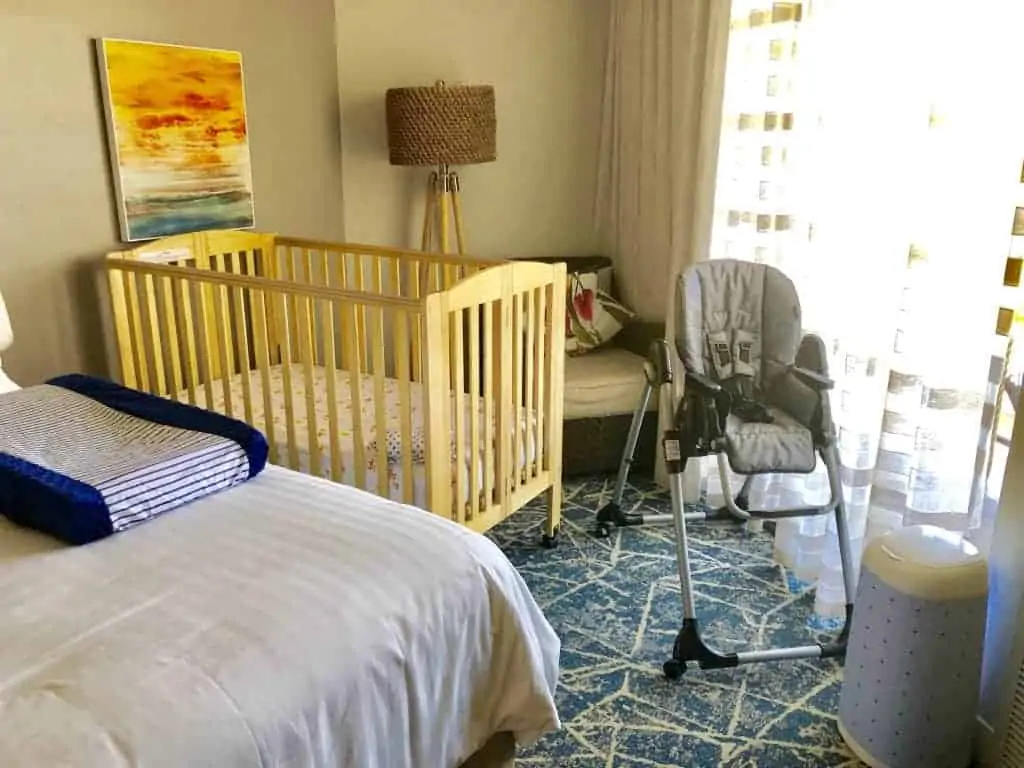 Hotel room with items from a baby equipment rental service.