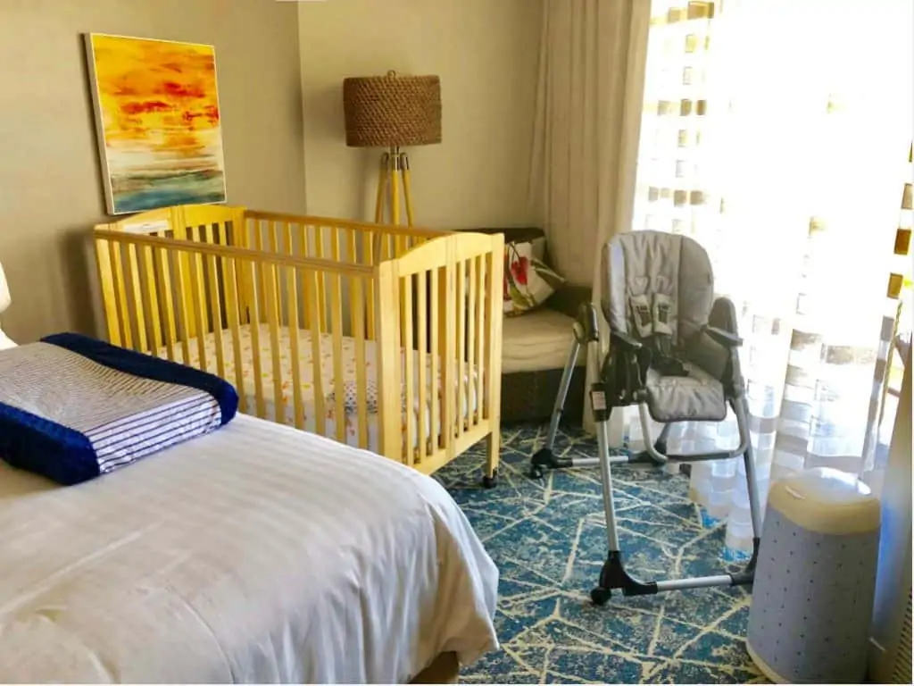 A hotel room with baby equipment from a rental company