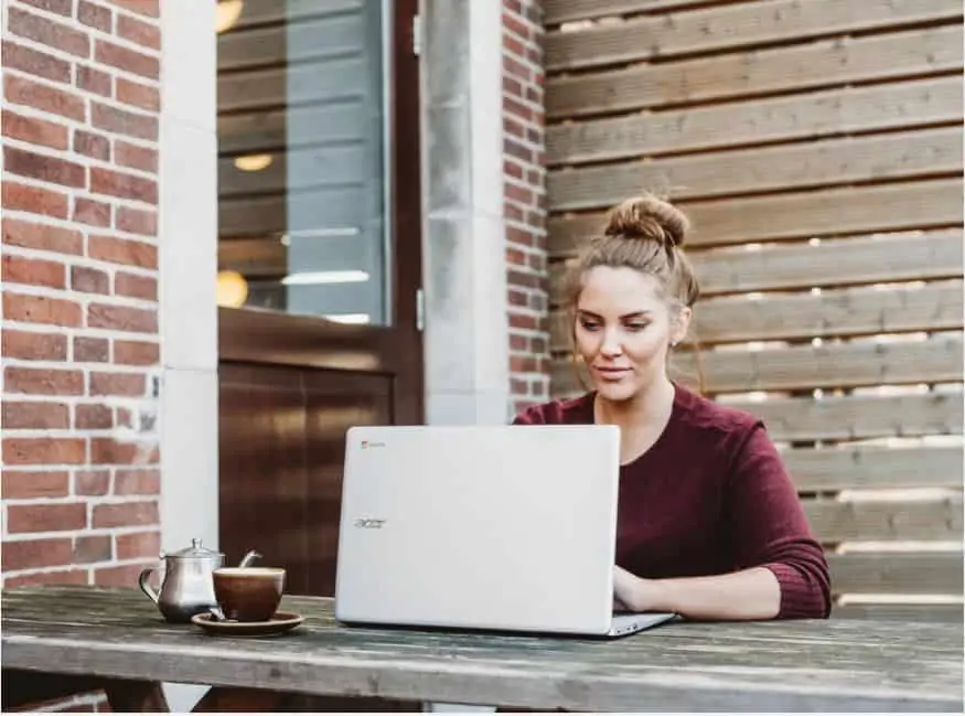 woman sitting outside on her laptop working on freelance jobs 