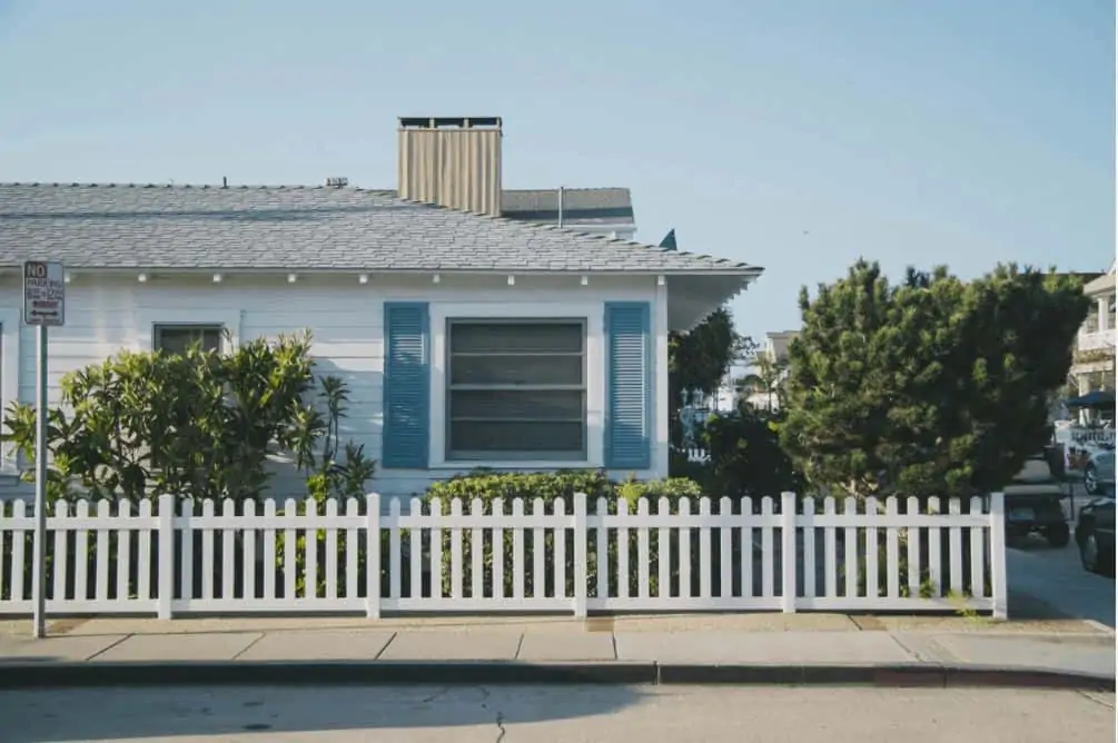A blue house with white trim and fence in foreclosure