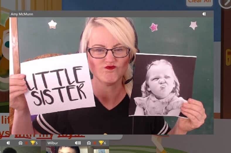 A woman showing a picture of a little sister to show her students what a little sister is