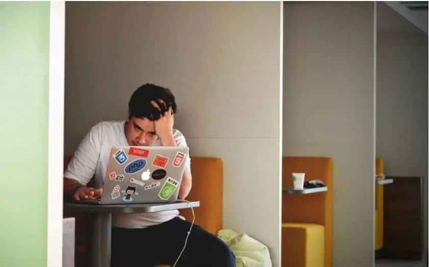 male college student looking at his computer