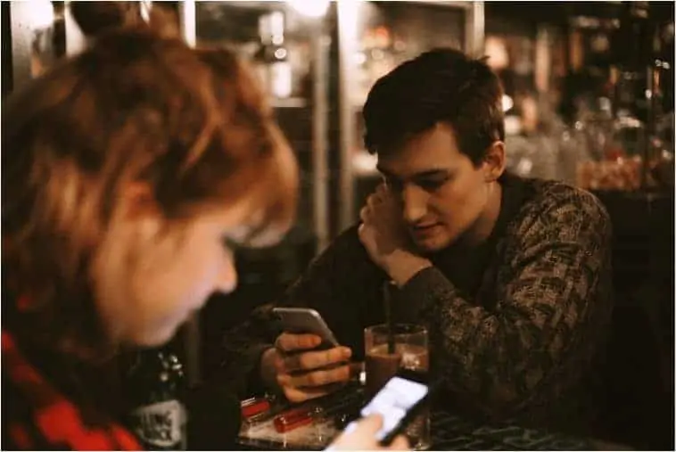 Two people looking at apps about how to earn money on their phones