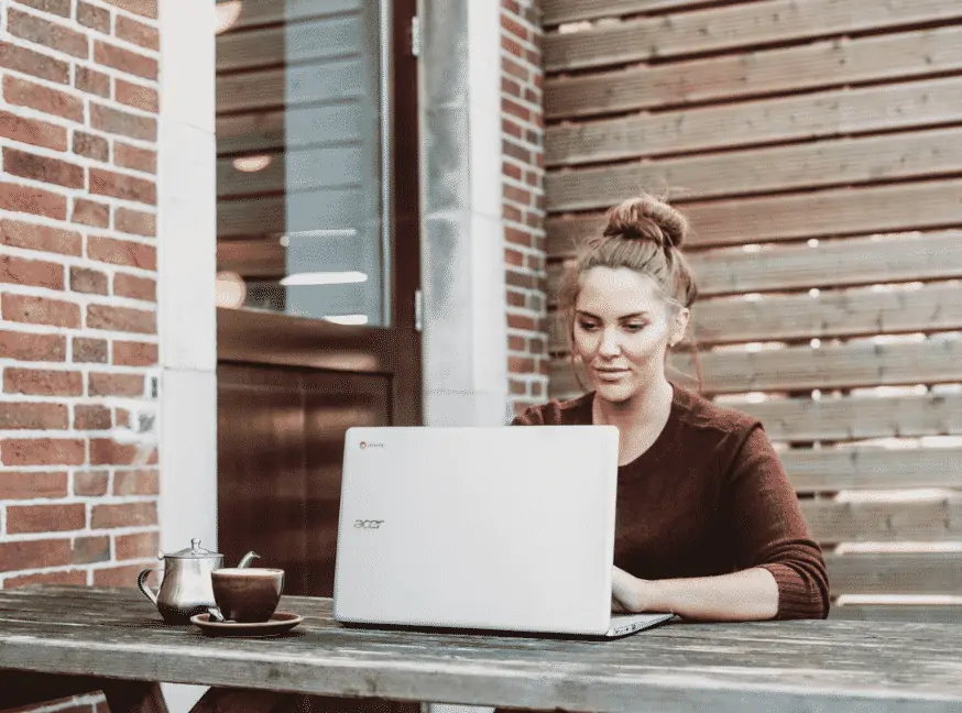 women outside on her laptop working on become a virtual assistant 