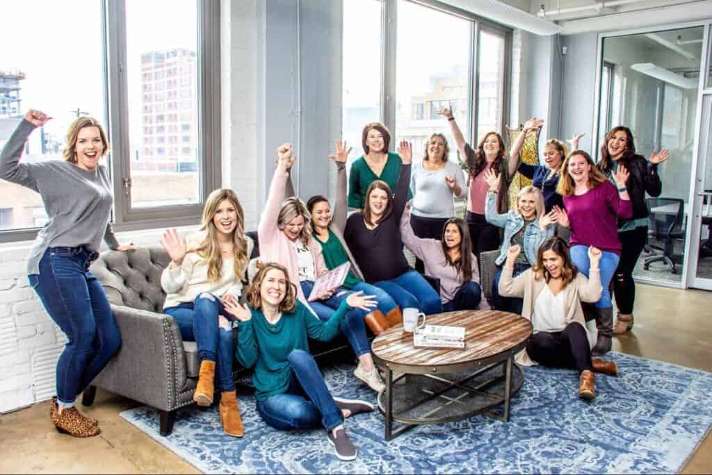 A group of women celebrating in an office.