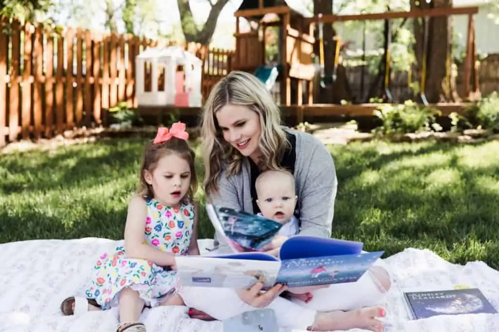 A woman working as a freelance writer while taking care of her children outside