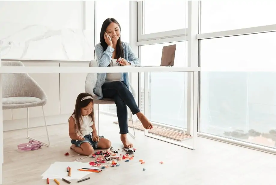 woman making working from home with her child playing with blocks next to her