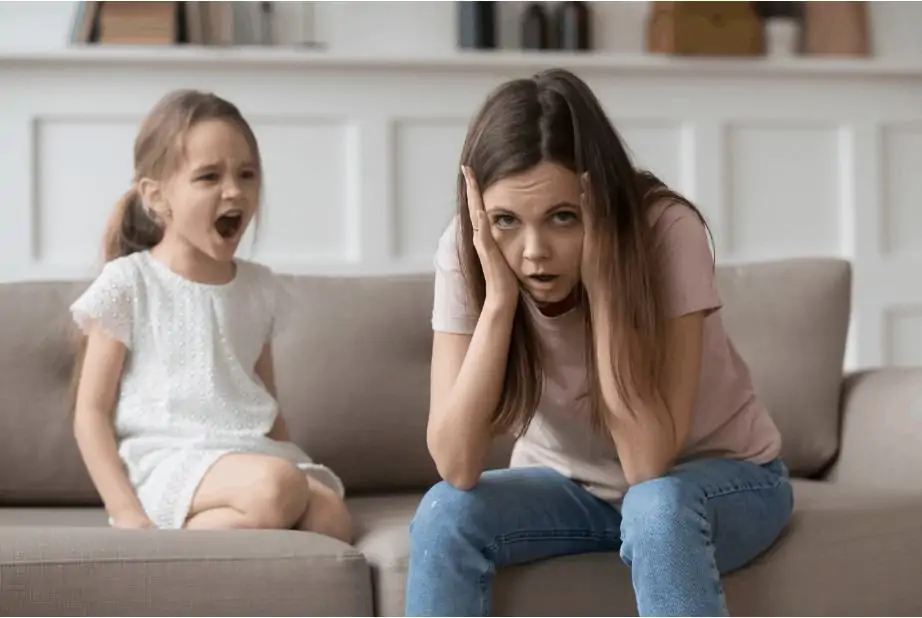 Stressed out mom with her kid yelling beside her