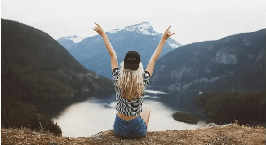 A mom overlooking a lake and enjoying time in nature by herself.