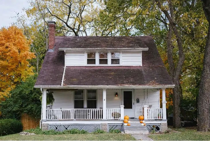 A white house in the woods that is run down