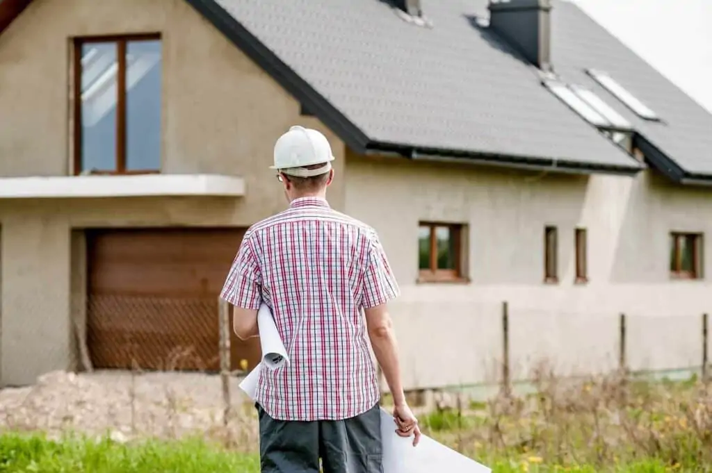 A man wearing a hard hat walking towards a building