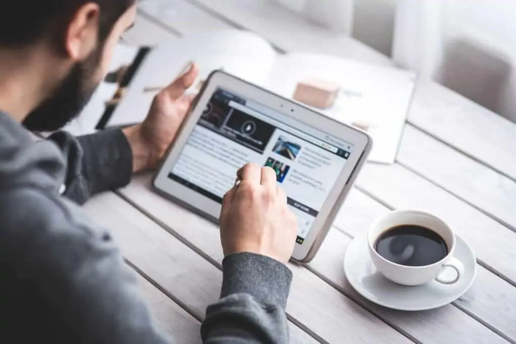 A man working on a tablet creating a newsletter