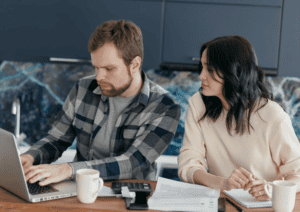 A man and woman working on a laptop together