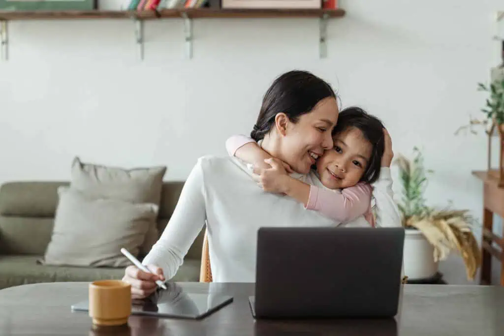 working mom by her computer in article on side hustles for moms