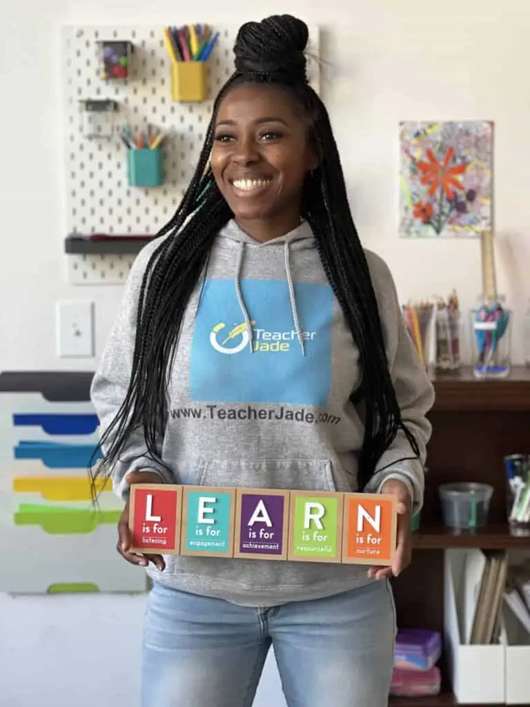 A woman holding blocks that spell "learn"