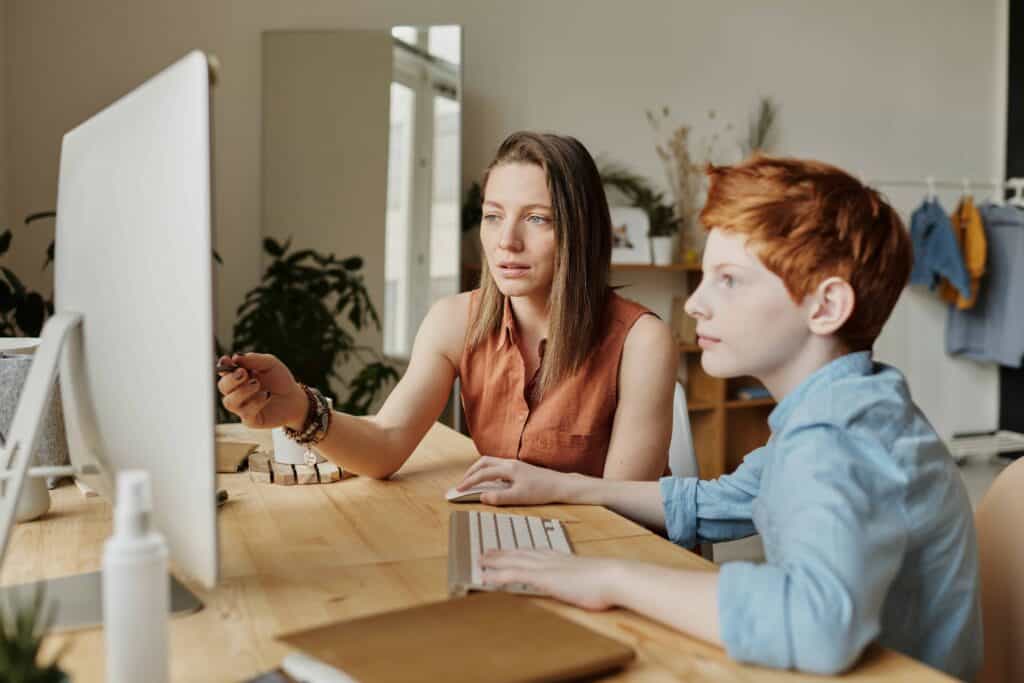 A woman teaching her son from home