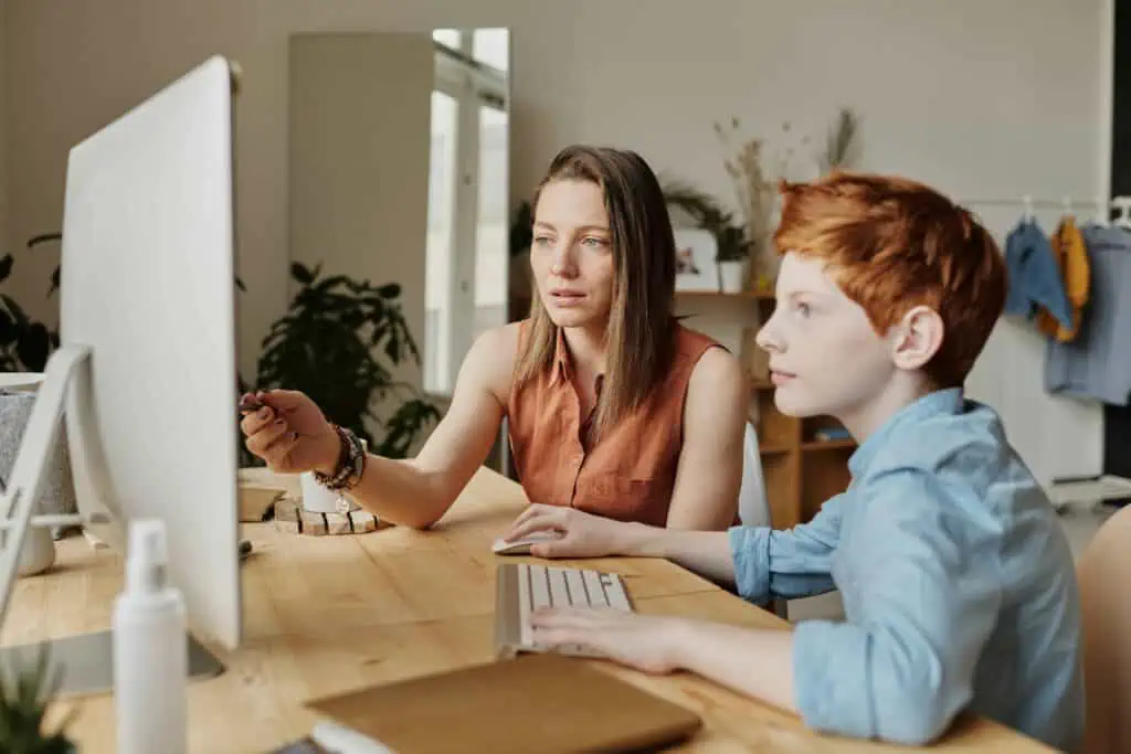 A woman teaching her son from home